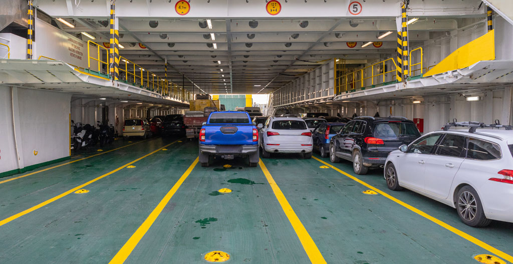 File de voitures au terminal ferry en été, conducteur consultant son téléphone